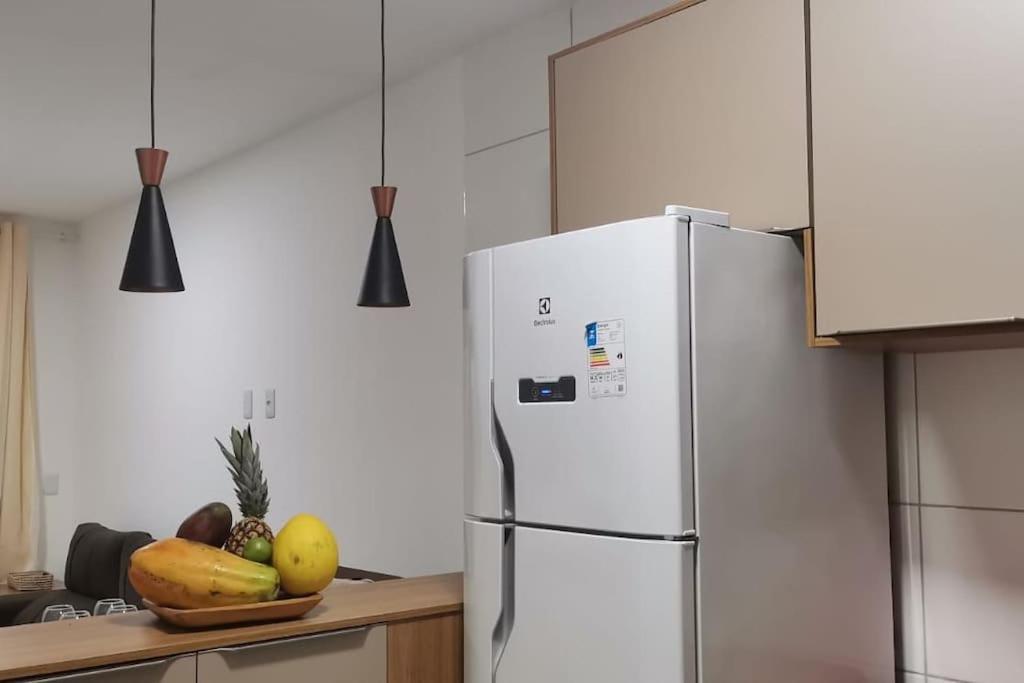 um frigorífico branco numa cozinha com uma taça de fruta em casa confortável em Camaçari