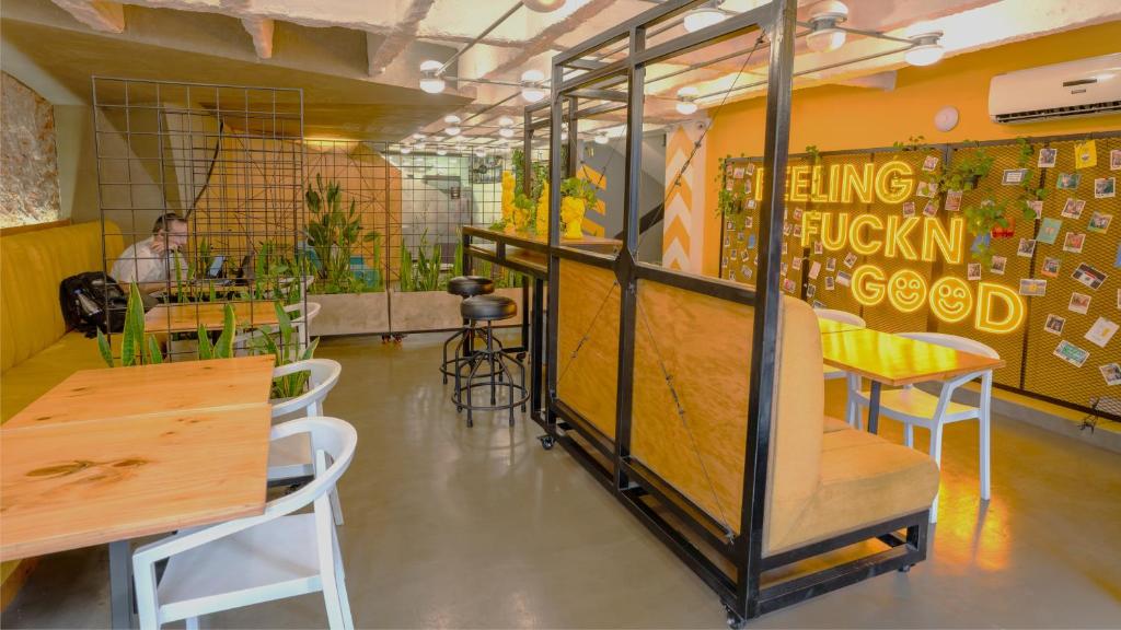 um restaurante com mesas e cadeiras e uma pessoa ao fundo em Hotel El Peñon by Bithotels em Cali