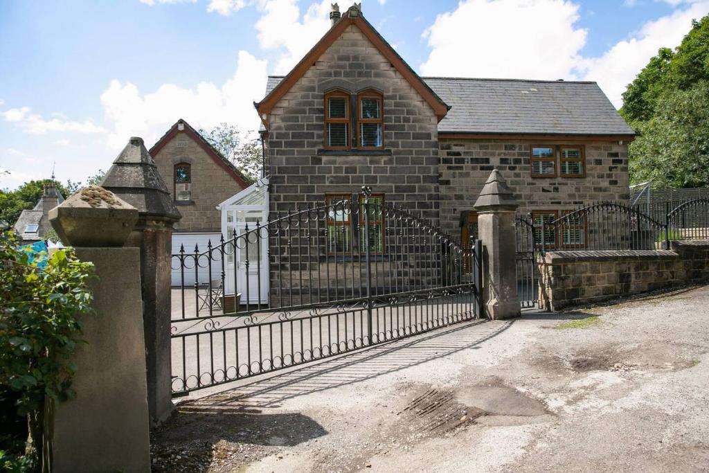 a stone house with a gate and a fence at Remarkable 4-Bed House Near Leeds Airport in Yeadon