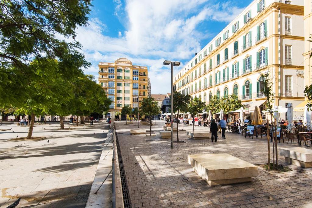 eine Straße in einer Stadt mit Gebäuden und Bäumen in der Unterkunft The 1st Corner Central Apartments in Málaga