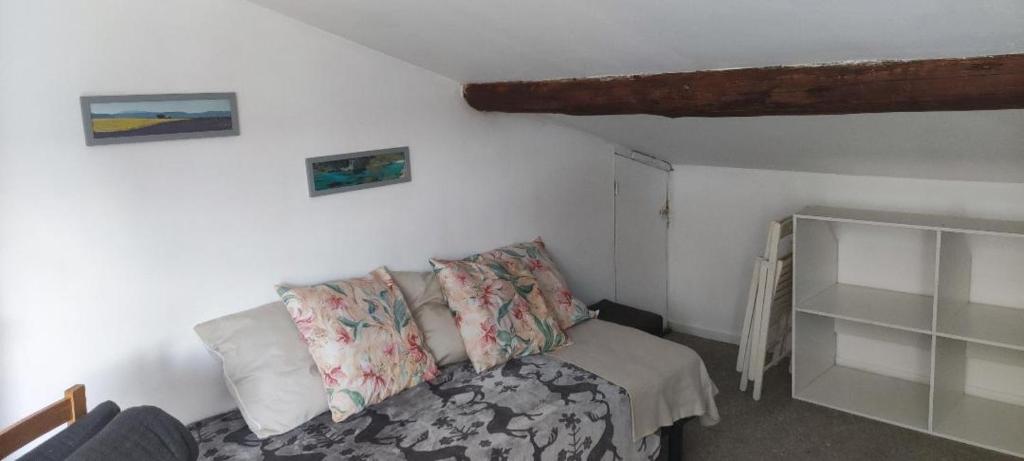 a room with a couch and a bed with pillows at Chez Bichette Saint Maximin in Saint-Maximin-la-Sainte-Baume