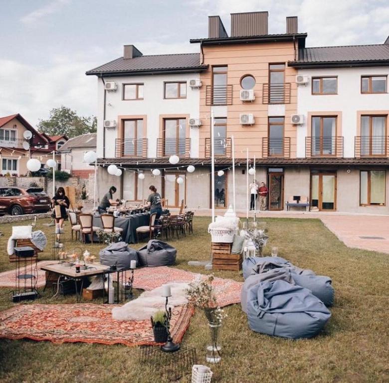een groot gebouw met tafels en stoelen in een tuin bij Carpe Diem in Chistilov