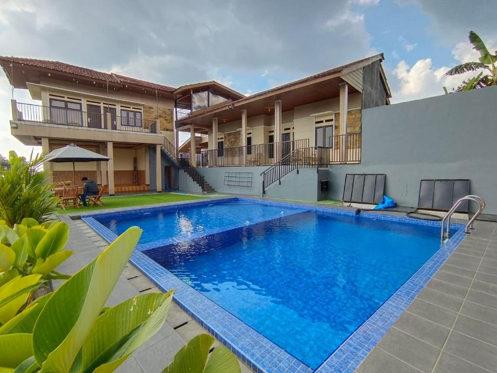 a swimming pool in front of a house at Villa Cisarua Ananda in Brujul