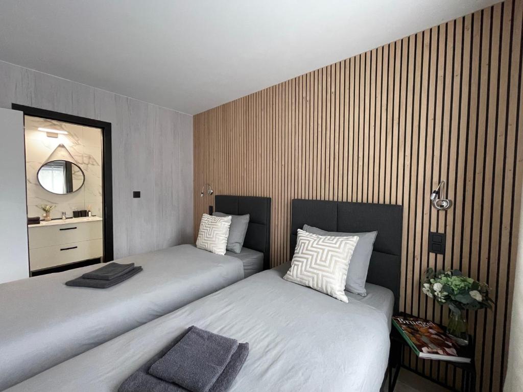 a bedroom with two beds and a mirror at Ferme du Château Fontaine in Fontaine-lʼÉvêque