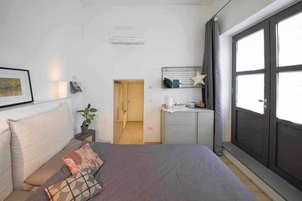 a bedroom with a bed and a couch and a door at Cozy room in the heart of Como in Como