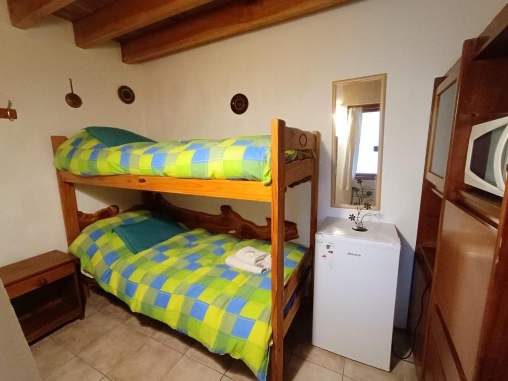 two bunk beds in a room with a sink at Dormi del Pellin in San Martín de los Andes