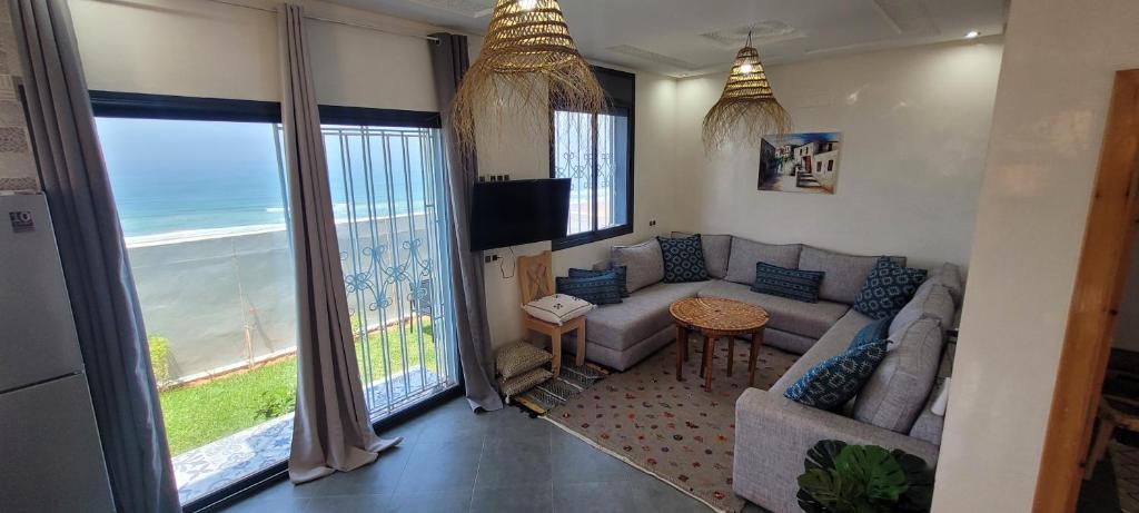 un soggiorno con divano e vista sull'oceano di Magnifique villa face à l'océan a Tiznit