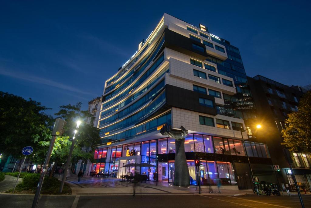 um edifício alto com janelas iluminadas à noite em EVOLUTION Lisboa Hotel em Lisboa