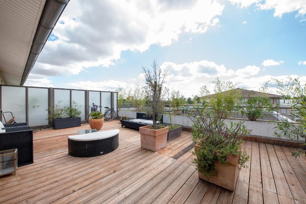 taras na dachu z meblami i roślinami na budynku w obiekcie Les terrasses - T3 Spacieux avec parking gratuit w Tuluzie