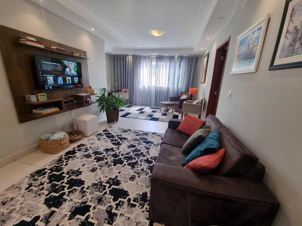a living room with a couch and a flat screen tv at Casa Gómez in São Lourenço