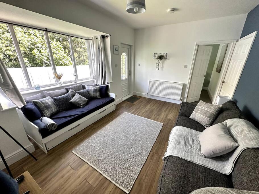 a living room with a couch and a large window at Seaside Snug - Gorgeous 2 Bed Seaside Bungalow in Hornsea