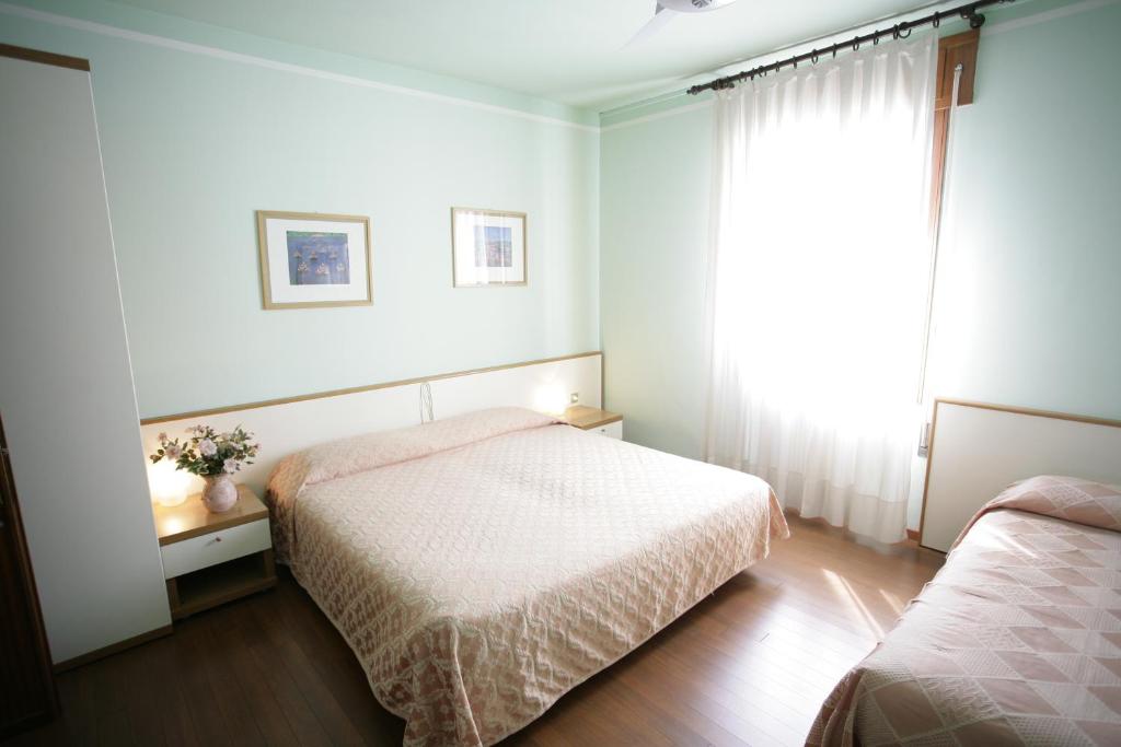 a bedroom with two beds and a window at Hotel Ezzelino in San Zenone