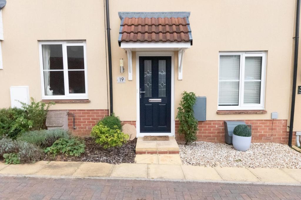 a brick house with a black door and windows at Arabian Nights in Swindon