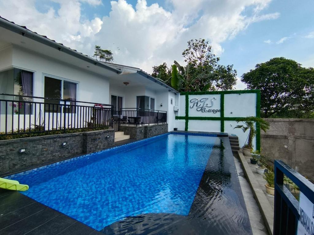 a swimming pool in front of a house at Villa Cisarua RJS in Brujul