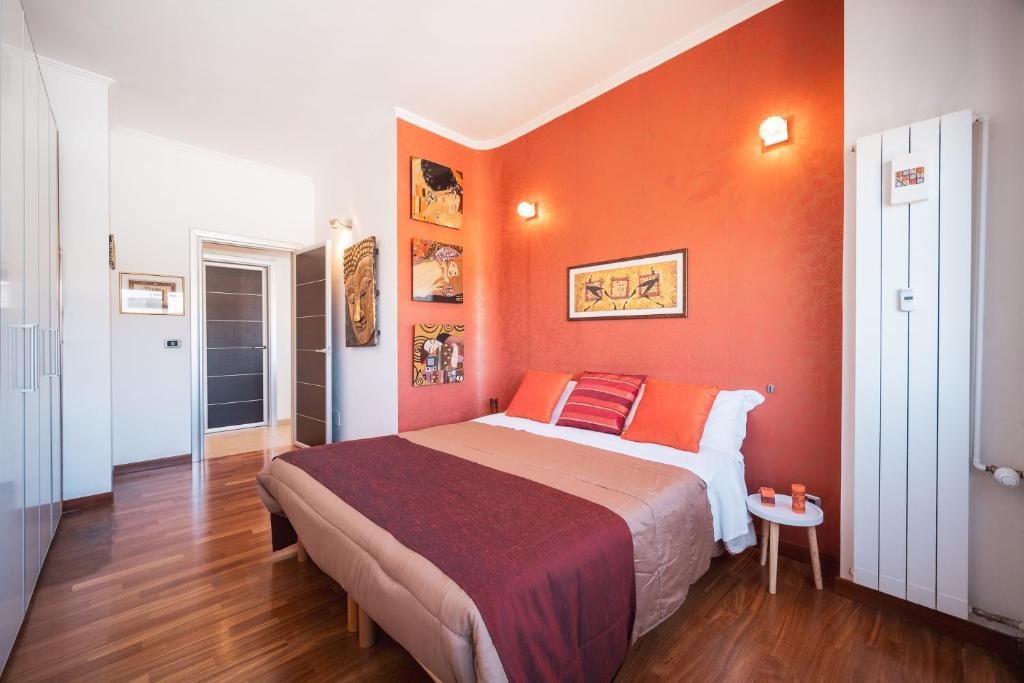 een slaapkamer met oranje muren en een bed in een kamer bij Tiber House 60 Rome Marconi - Rome Vacation M&D in Rome