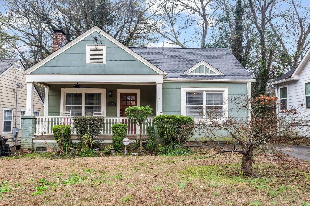 ein blaues Haus mit einer Veranda und einem Hof in der Unterkunft Southern Comfort in Atlanta