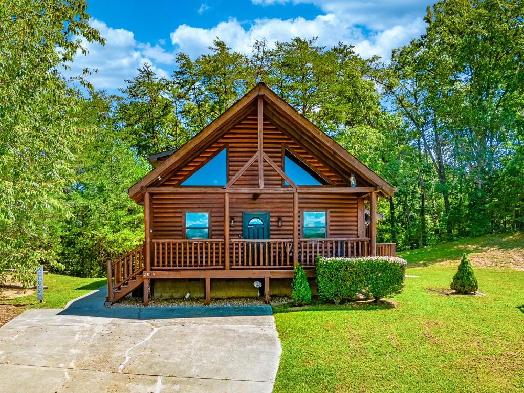 une grande cabane en rondins avec une grande véranda dans l'établissement Southern Grace, à Pigeon Forge