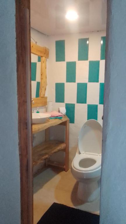 a bathroom with a toilet and a sink at Cabaña en la Calera el refugio campestre in La Calera