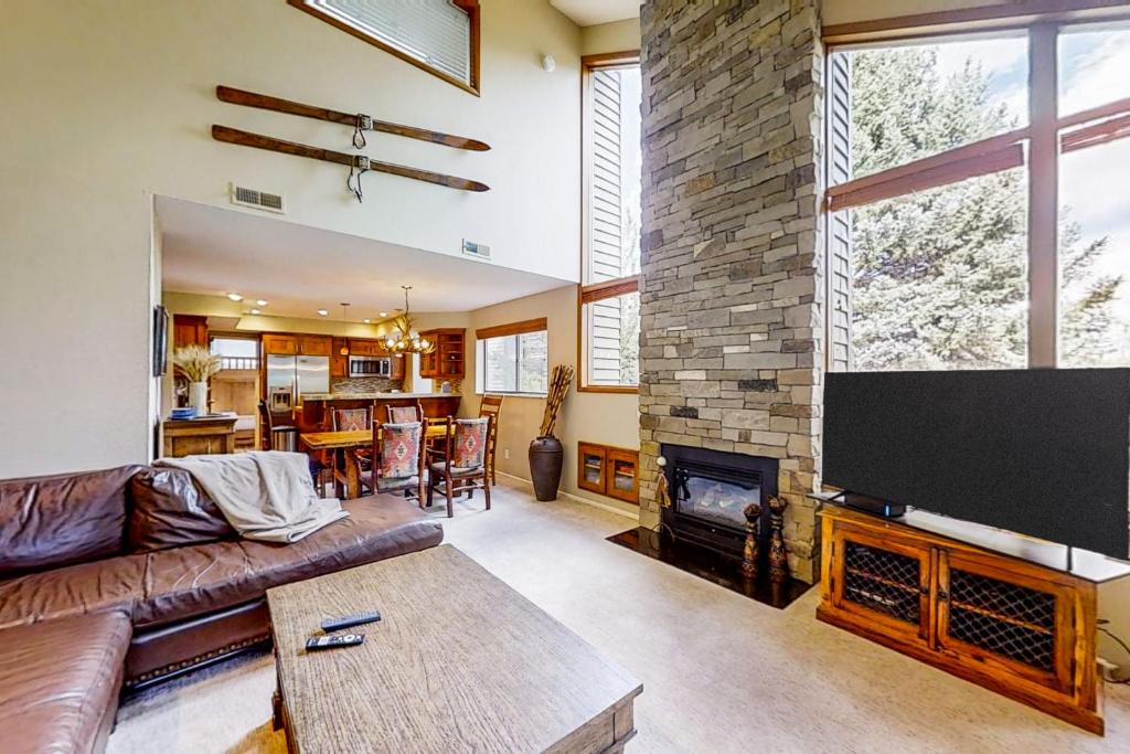 uma sala de estar com uma grande televisão e uma lareira em Red Pine Canopy em Park City
