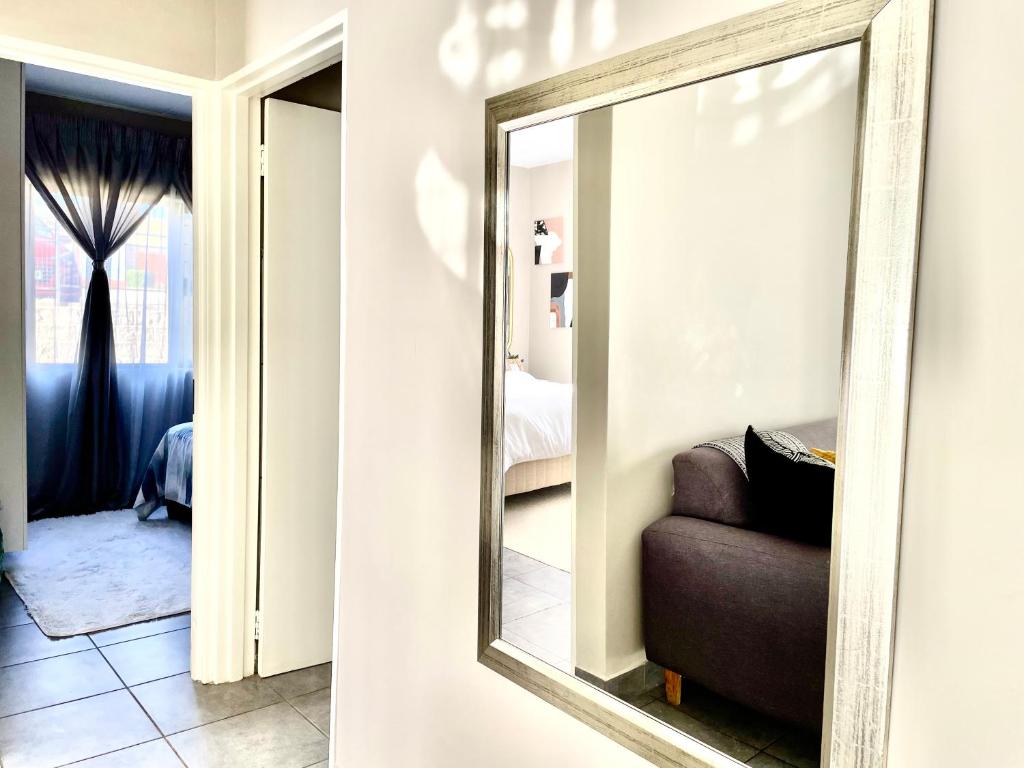 a mirror on a wall next to a couch at Central and peaceful 2-bedroom Apt #ZonaHomes in Midrand