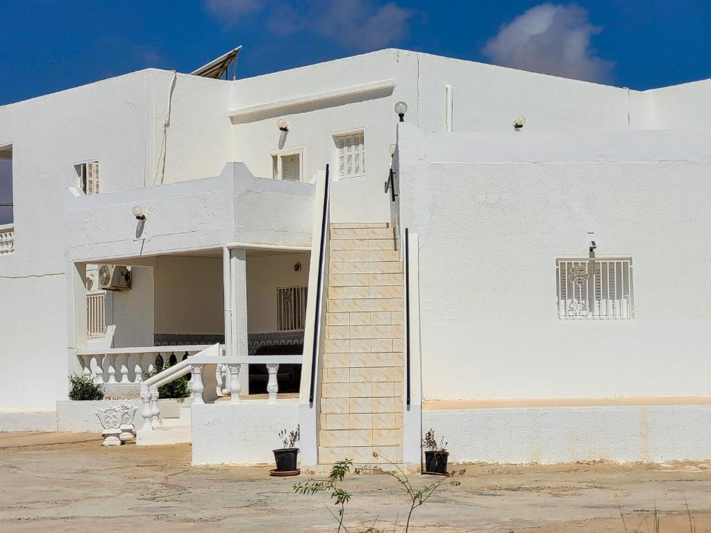 a white building with stairs in front of it at Yassmine in Djerba