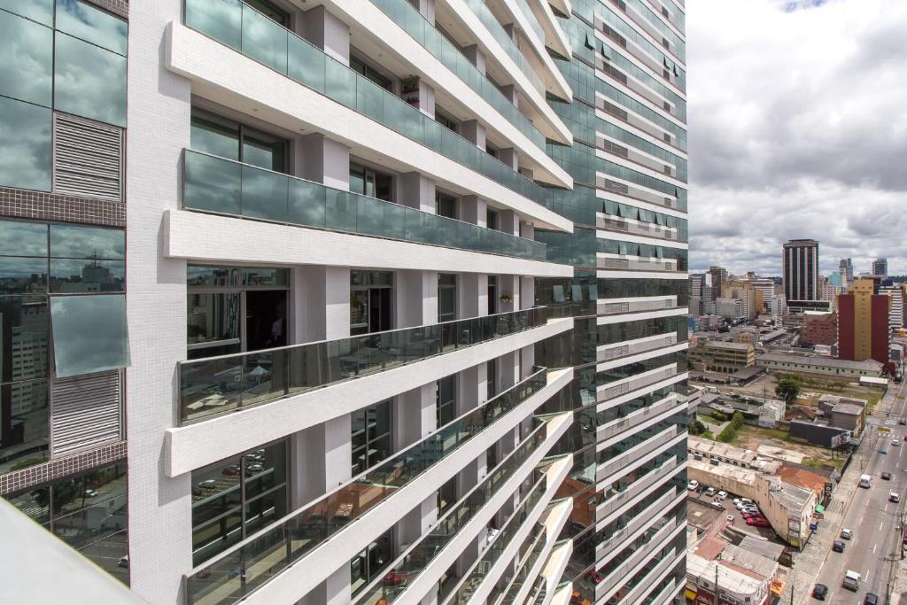 un immeuble d'appartements avec balcon et une ville dans l'établissement 7th Avenue Residence, à Curitiba