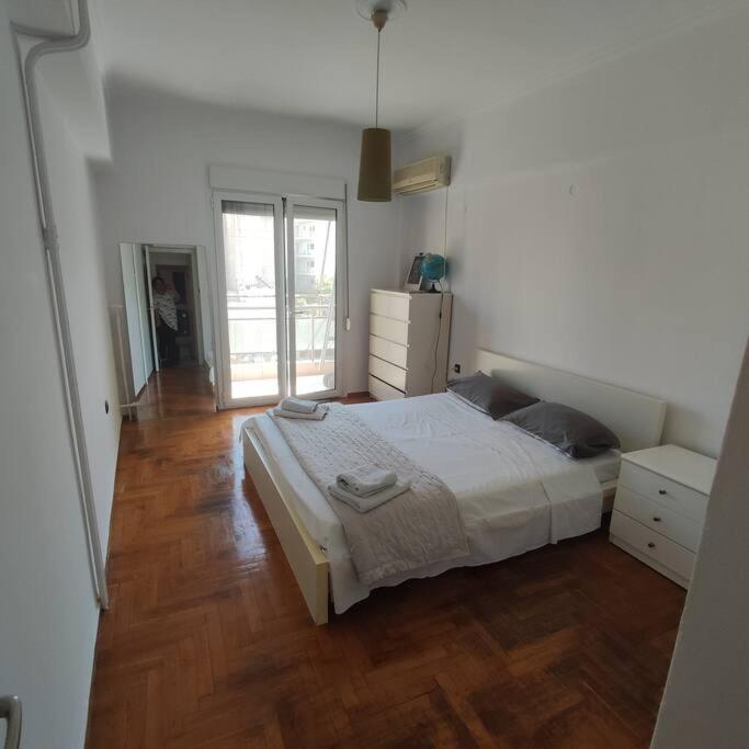 1 dormitorio con 1 cama grande y suelo de madera en CENTRAL ATHENS APARTMENT, en Atenas