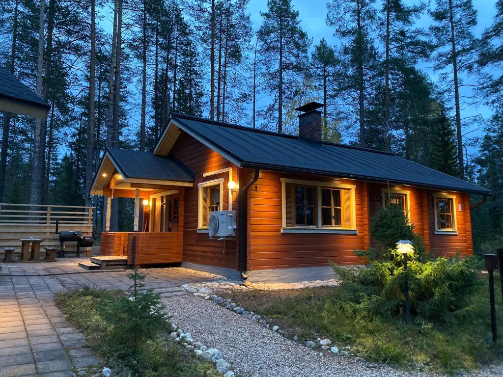 a small wooden cabin in the middle of a forest at Lomanaamanka Villa Kanerva in Syöte