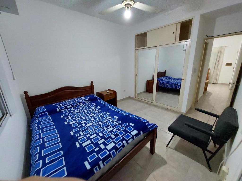 a bedroom with a bed and a chair and a mirror at Departamento temporario céntrico in Corrientes