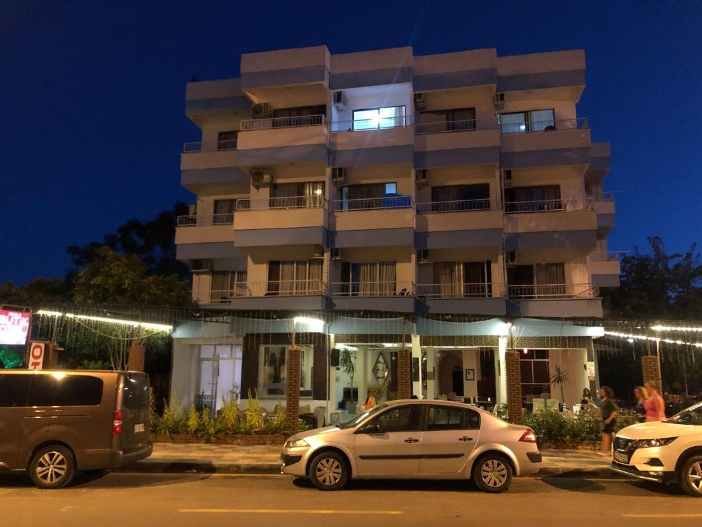 two cars parked in front of a building at night at Anamur Butik Otel in Anamur