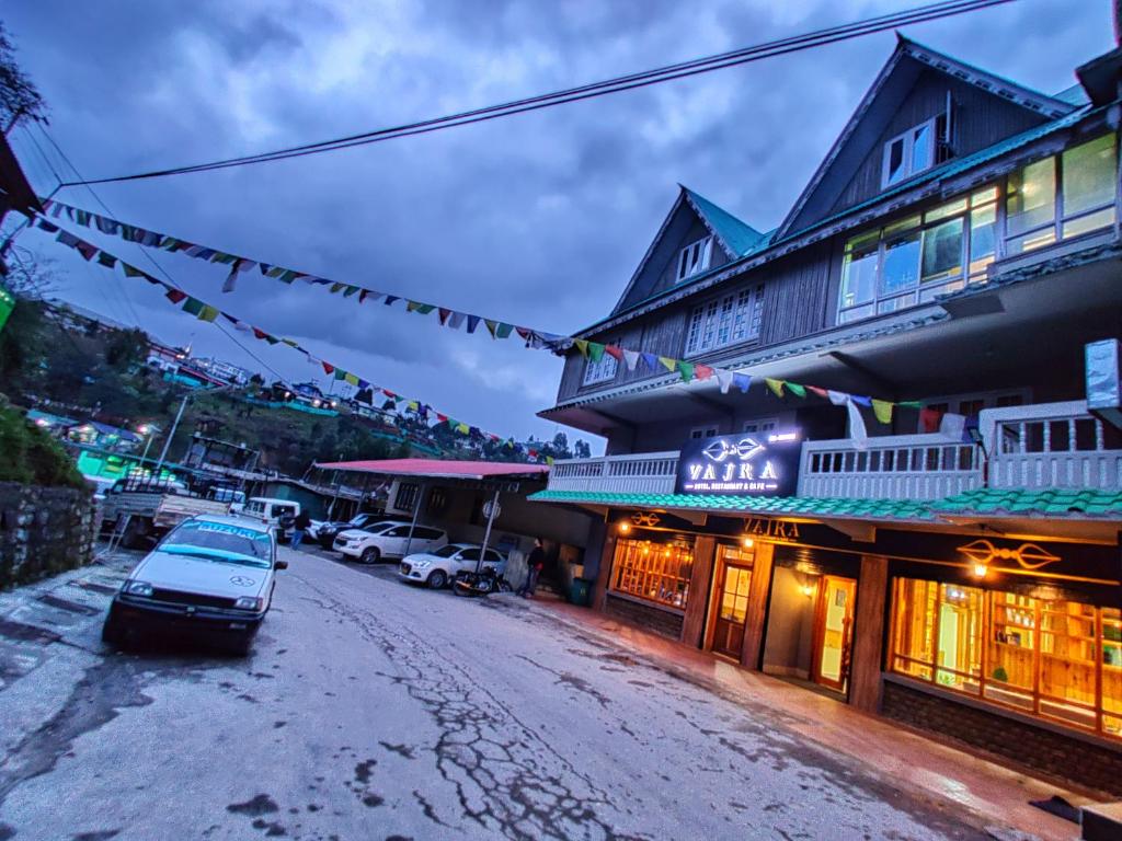 a street in front of a building with a car parked in front at Hotel Vajra in Tawang