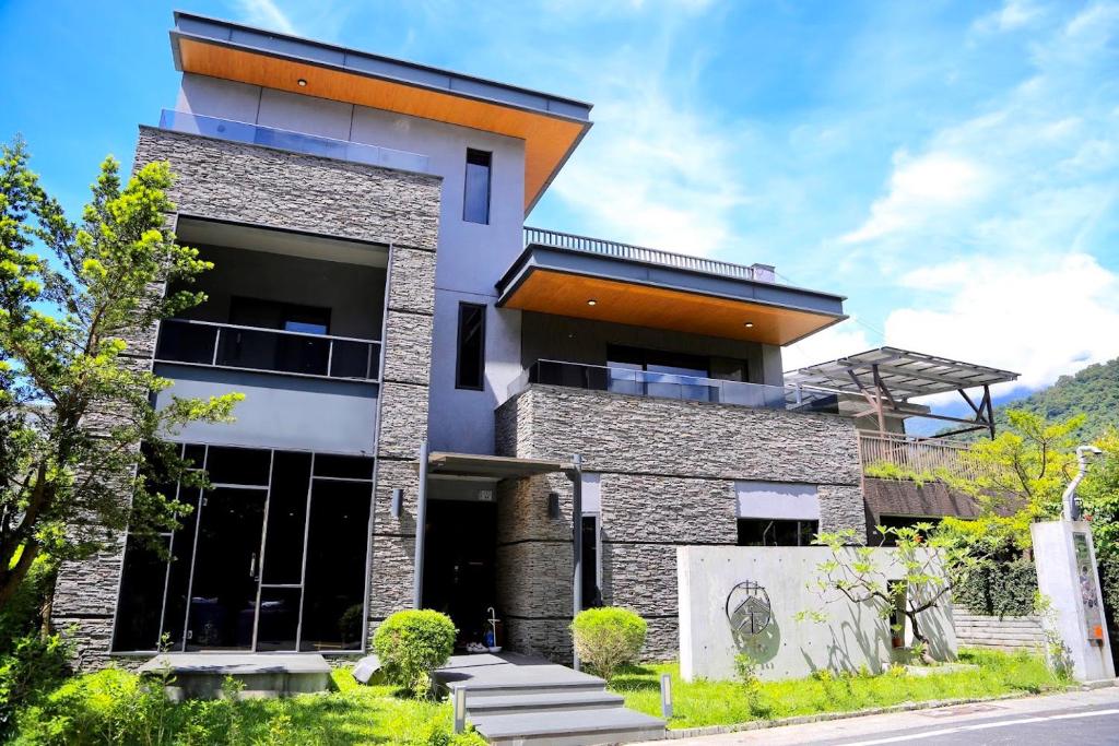 a modern house with a stone facade at 茶田關舍民宿Tea Paddy B&B in Guanshan