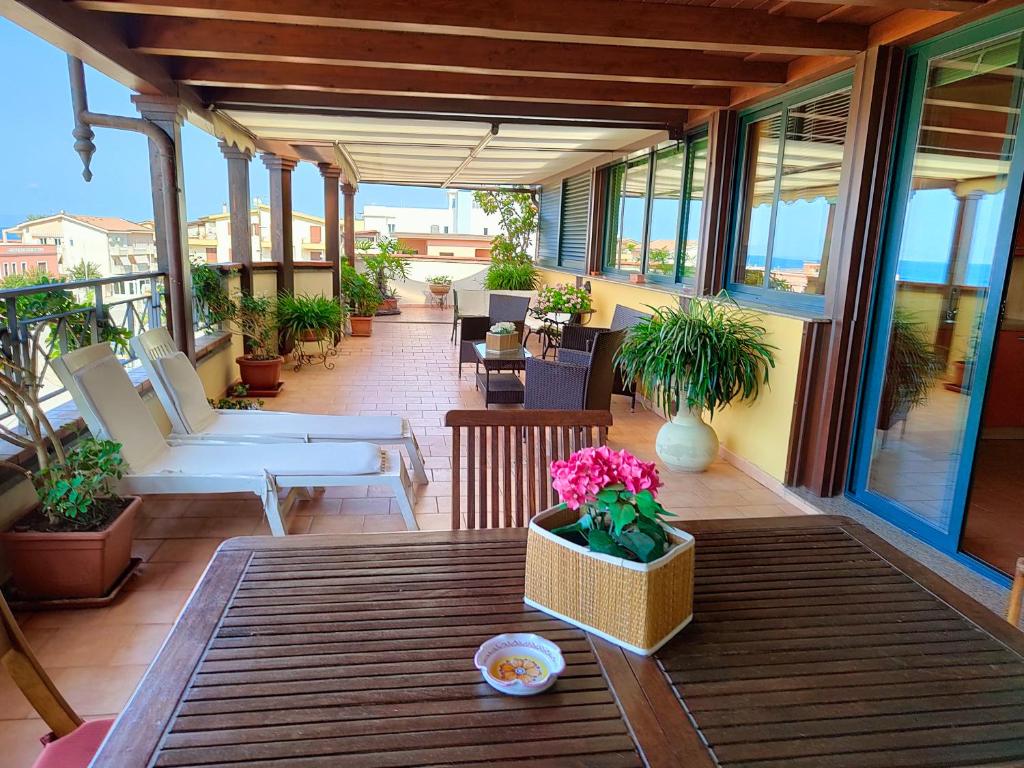 een patio met een tafel en stoelen op een balkon bij "Appartamento del Mare Gliaca" con vista Isole Eolie,ampia terrazza,wifi e parcheggio gratuito in Piraino
