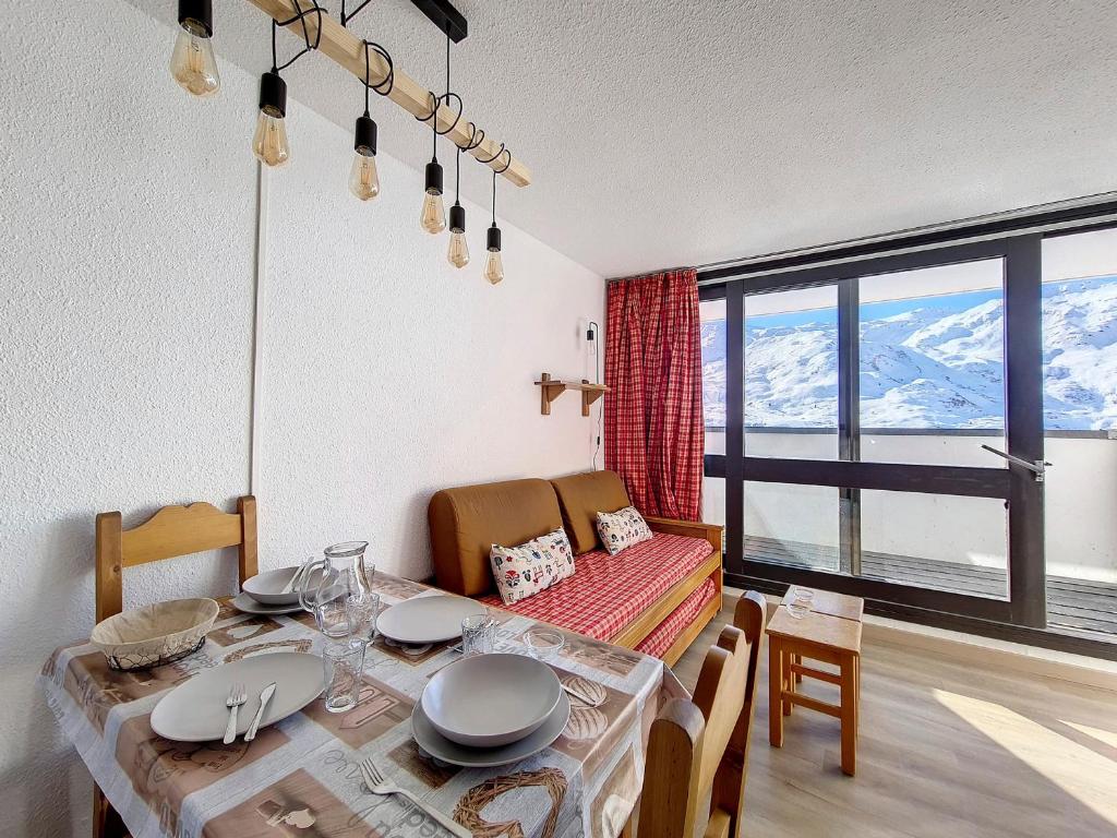 d'une salle à manger avec une table et une vue sur les montagnes. dans l'établissement Studio Lumineux 4 Pers, Accès Pistes, Balcon SO, Près Commerces et Remontées, Non Fumeur, Animaux Refusés - FR-1-344-990, aux Menuires
