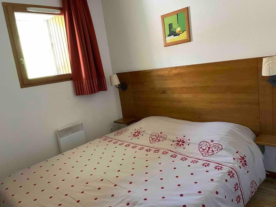 une chambre avec un lit avec une tête de lit en bois dans l'établissement Résidence Étoile Orion - Appartement au pied des pistes, à Orcières