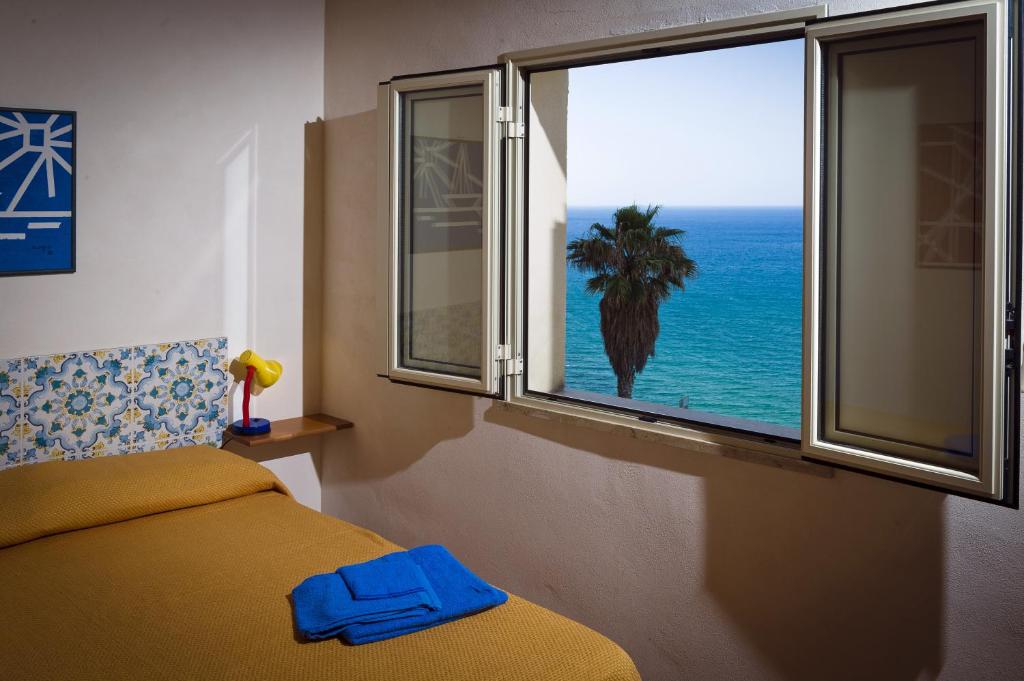 a bedroom with a bed and a view of the ocean at Appartamento sul mare in Castellammare del Golfo
