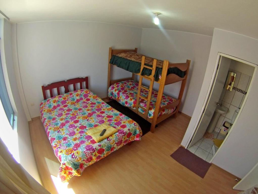 een kleine slaapkamer met 2 stapelbedden en een spiegel bij Pillku Hospedaje in Huarmey