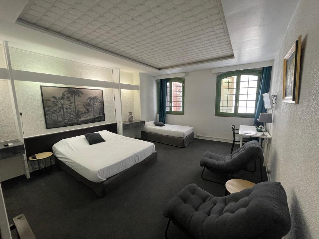 een slaapkamer met een bed en 2 stoelen. bij Hôtel De La Loge in Perpignan