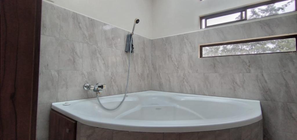 a white bath tub in a bathroom with a window at Casa Terra in Cuenca
