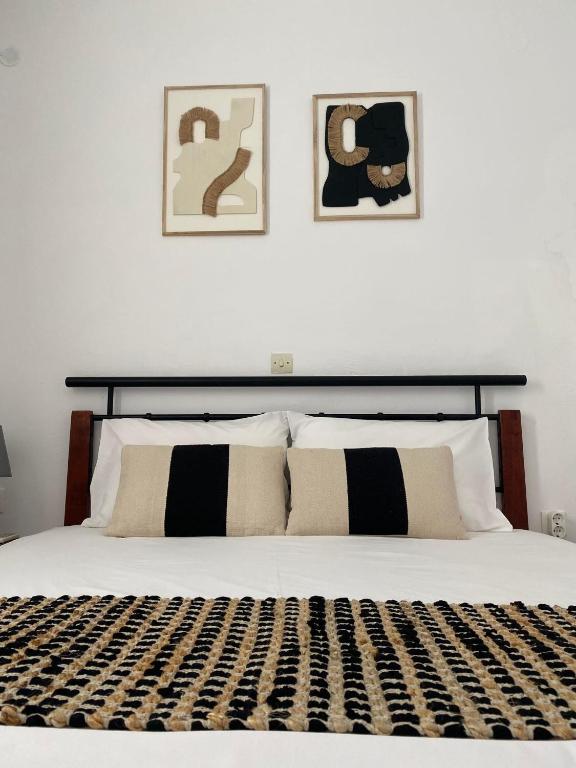 a bed with black and white pillows in a bedroom at Mare Blu Sole in Karpathos