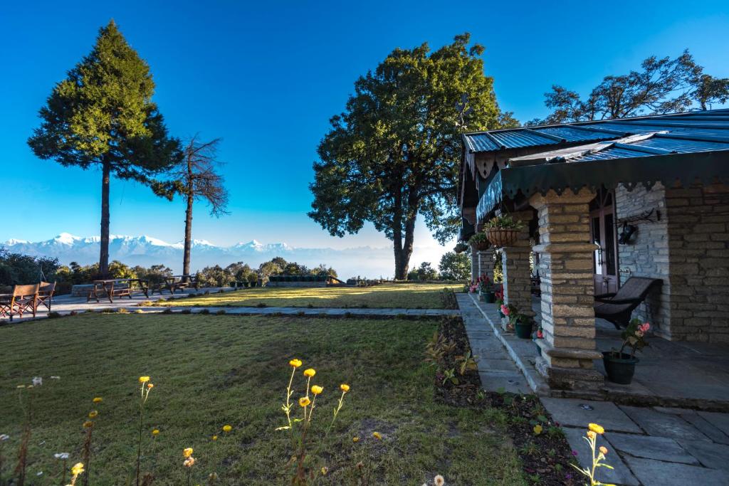 a house with a garden and a lawn with flowers at Nine Furlongs, Binsar Wildlife Sanctuary in Almora