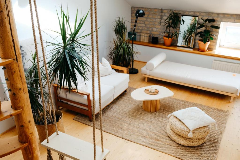 a living room with white furniture and potted plants at White Loft in the Riga City Center in Rīga