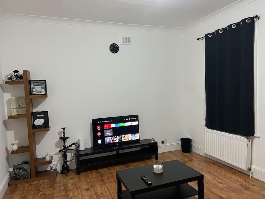 a living room with a flat screen tv on a wall at 1 Bedroom Home With Free Parking & Private Garden in London