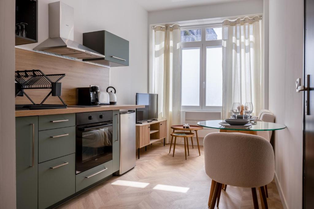 a kitchen with a table and a dining room at La Perle Citadine En Hyper Centre in La Rochelle