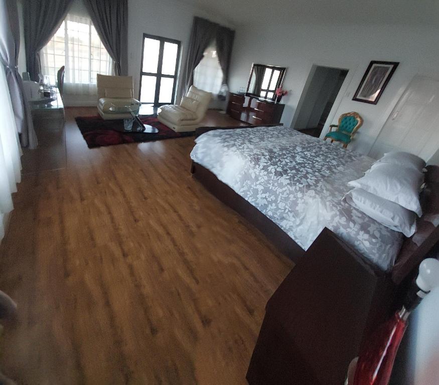 - une chambre avec un grand lit et du parquet dans l'établissement 46 Charles Street, Grootfontein Country Estate.Pretoria East, à Tierpoort