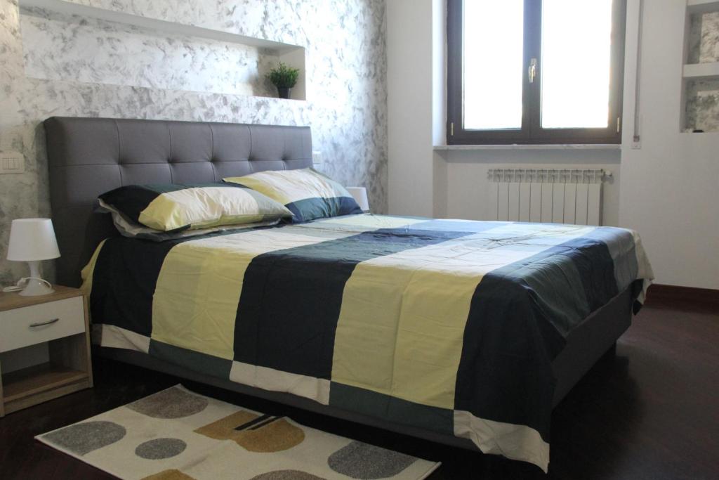 1 dormitorio con 1 cama con manta negra y amarilla en Capital House Roma, en Roma
