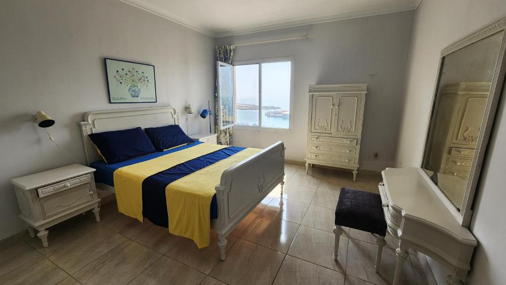 a bedroom with a bed with blue and yellow sheets at سابا باشا 3 in Alexandria