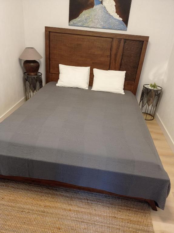 a bed with a wooden headboard and two pillows at Ubytování Němčičky in Němčičky