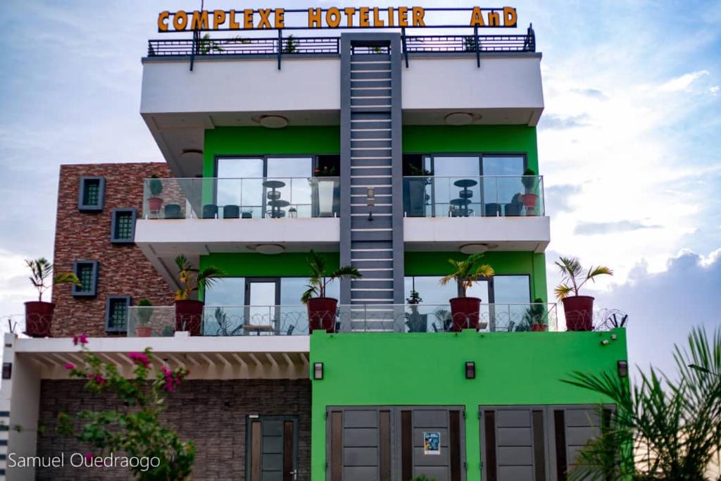 a building with a green building with a sign on it at Complexe Hôtelier AnD in Ouagadougou