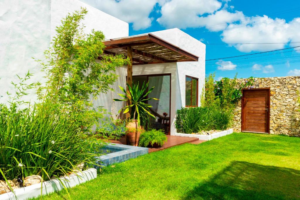 ogród z domem z trawnikiem w obiekcie Vila de Charme w mieście São Miguel do Gostoso